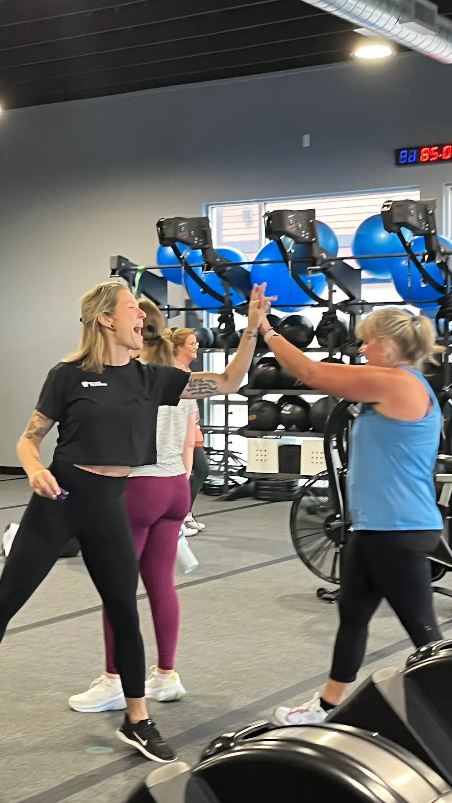 A coach and member high-fiving mid-session