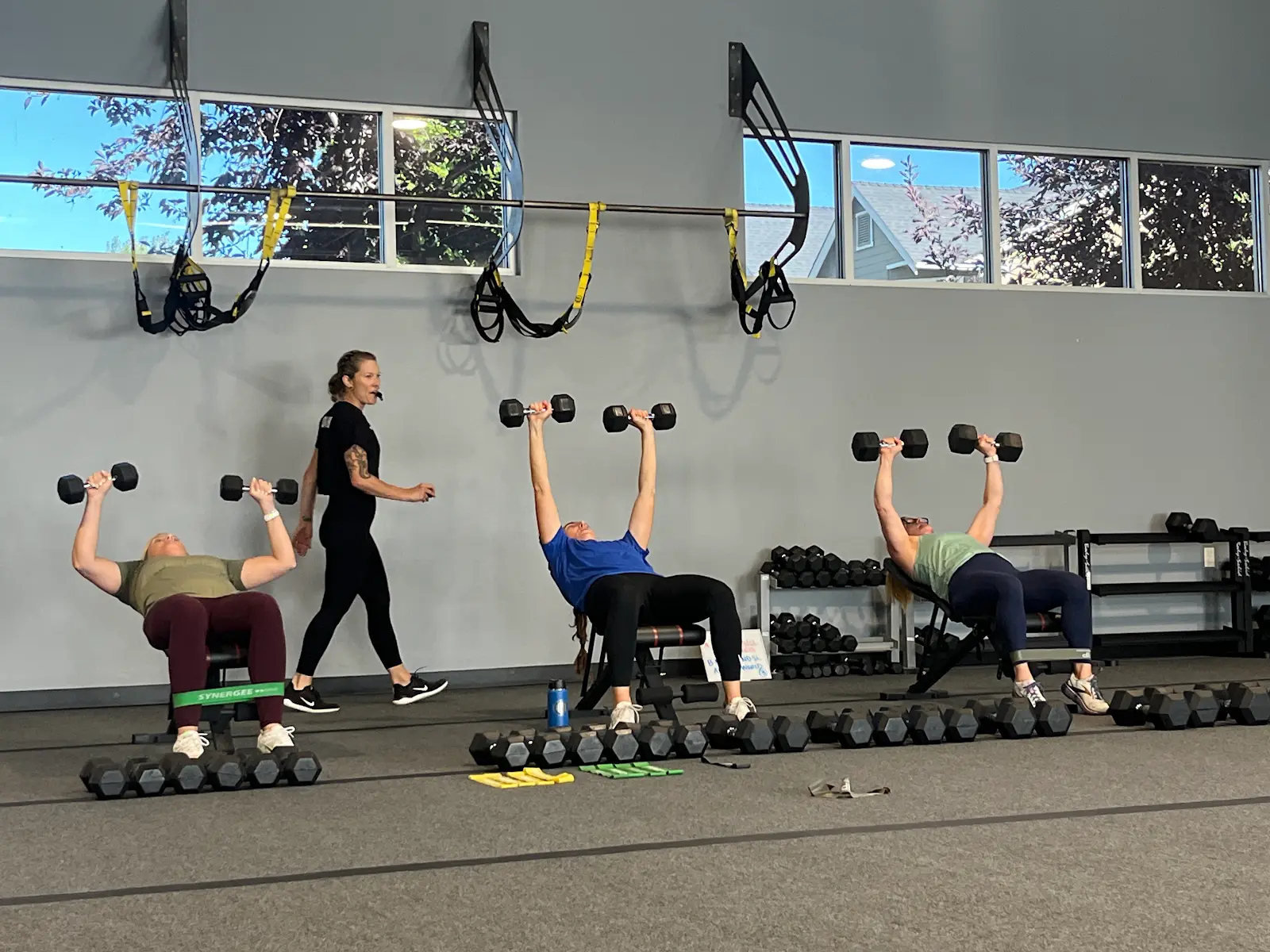 A Ritual Training Portland coach guiding members through a dumbbell press